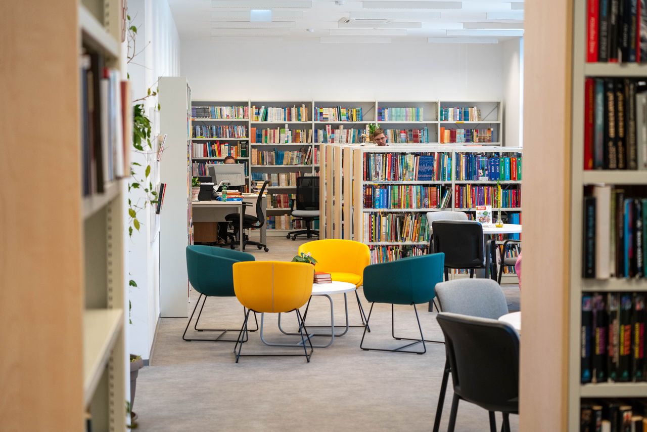 Reinigung von Bildungseinrichtungen Aachen​ – Bild einer Bibliothek von innen mit Sitzmöglichkeiten und Tischen.