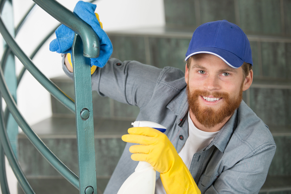 Professionelle Treppenhausreinigung – Mitarbeiter reinigt gründlich das Treppenhaus.